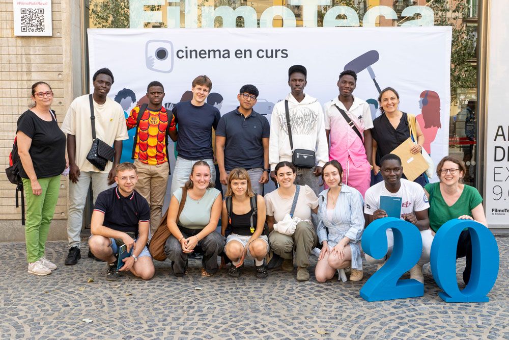 Pòster del documental 'Bajo el polvo, nuestra tierra'. Mostra una vista aèria d'un tren que passa per una zona desèrtica, amb unes muntanyes al fons. El tren sembla estar carregat de carbó i passa per un paisatge que ha estat afectat per la mineria. El títol del documental es troba a la part central de la imatge i els crèdits a la part superior i inferior.